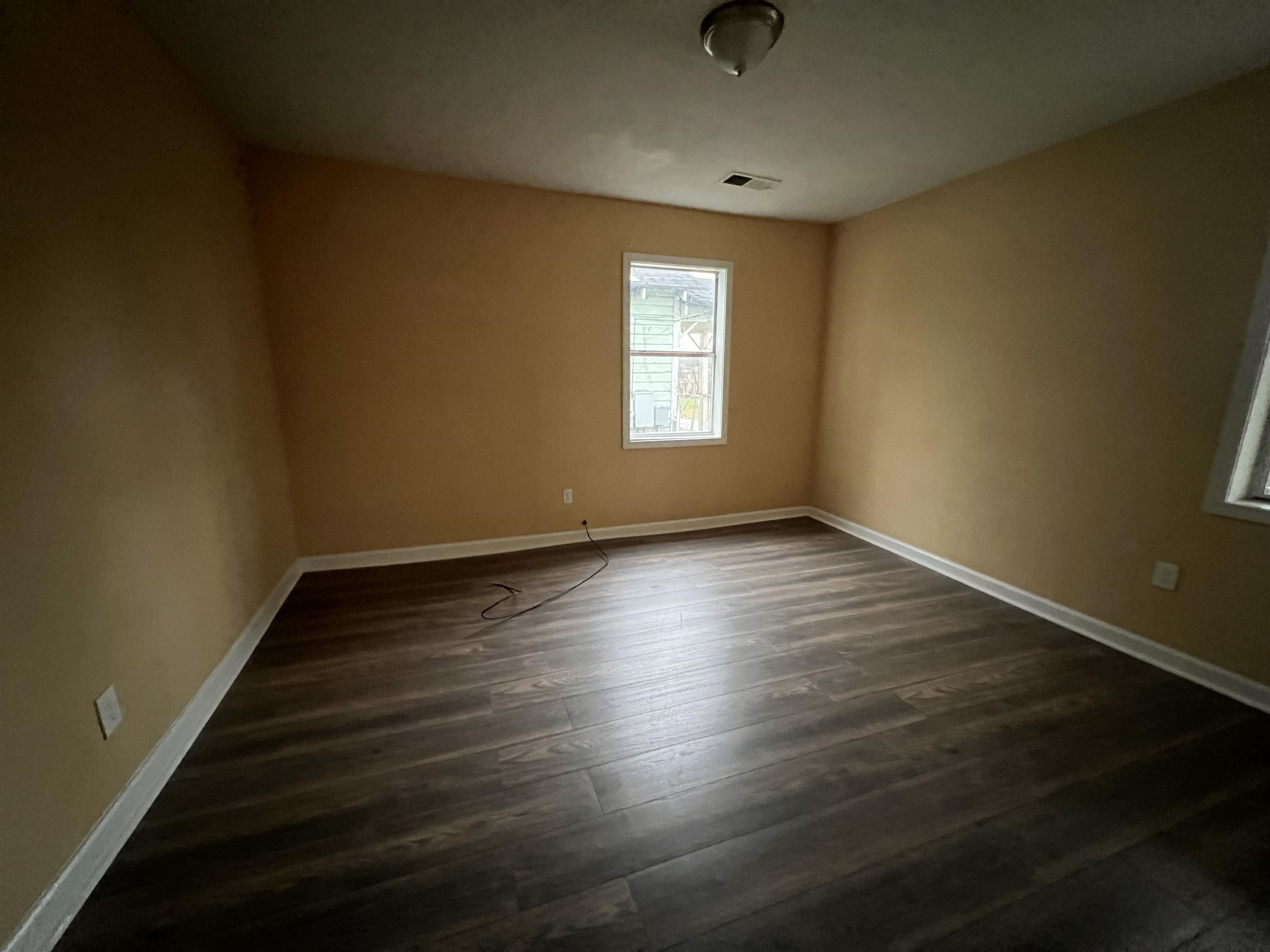 1393 Michigan Street Memphis, TN 38106 - Photo 20 of 27 an empty room with wooden floor and windows