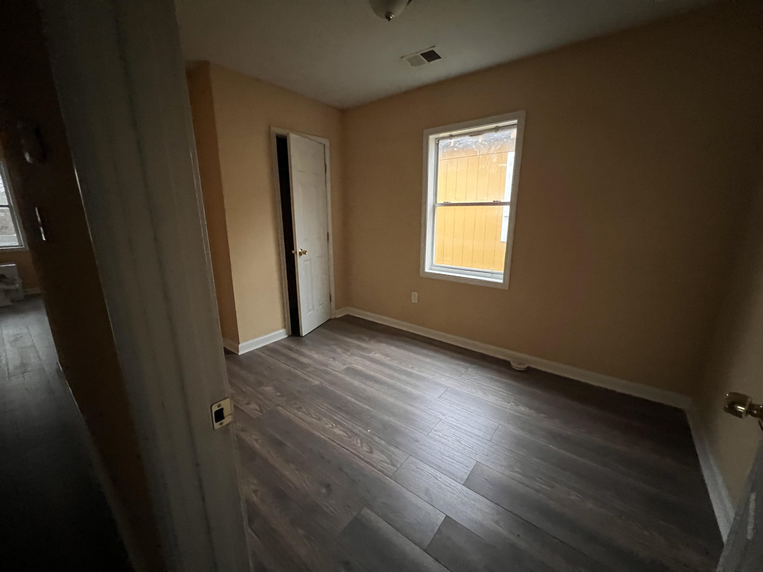 1393 Michigan Street Memphis, TN 38106 - Photo 23 of 27 a view of an empty room with wooden floor and a window