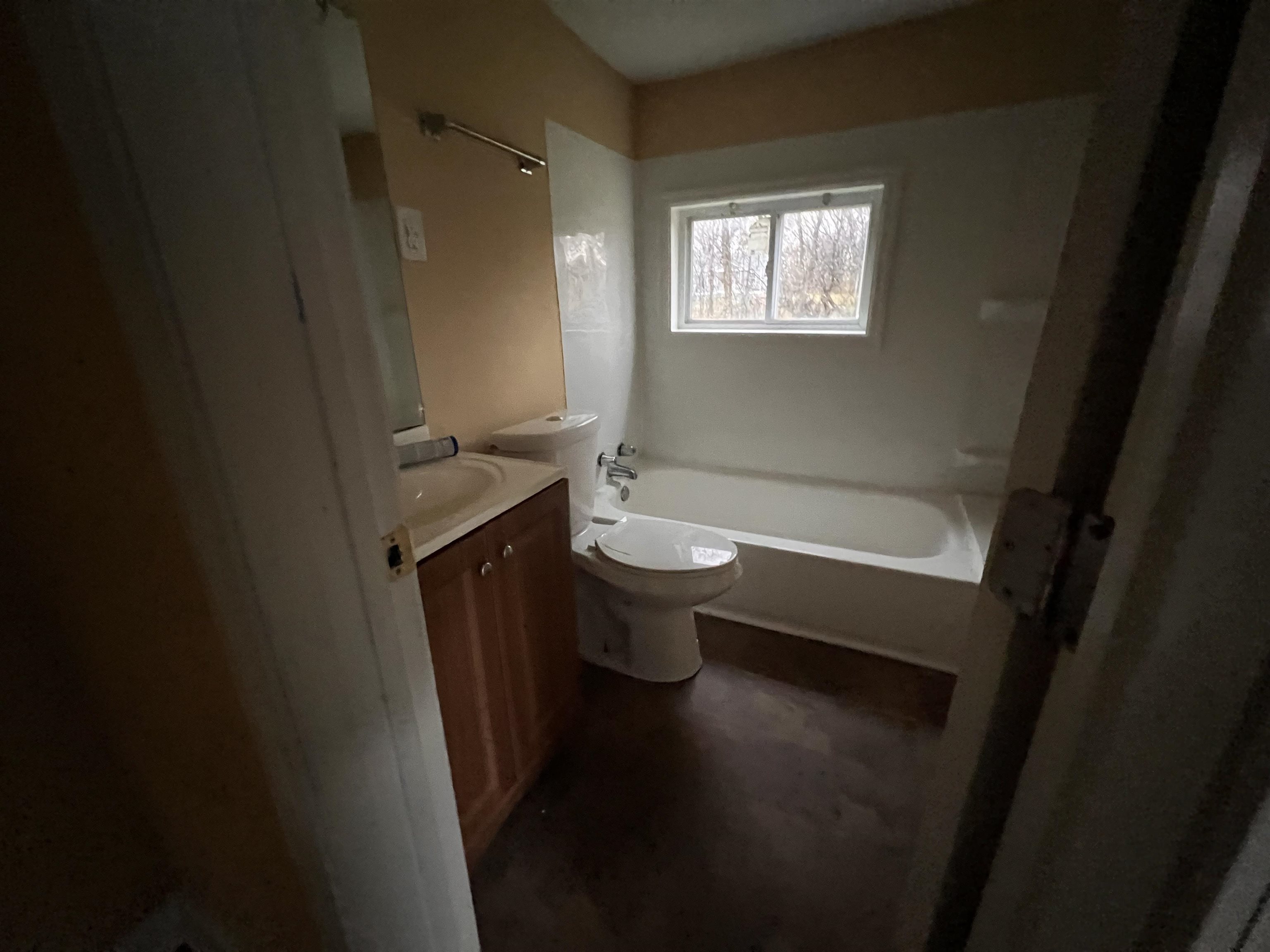 1393 Michigan Street Memphis, TN 38106 - Photo 27 of 27 a bathroom with a sink a toilet a shower a mirror and a window