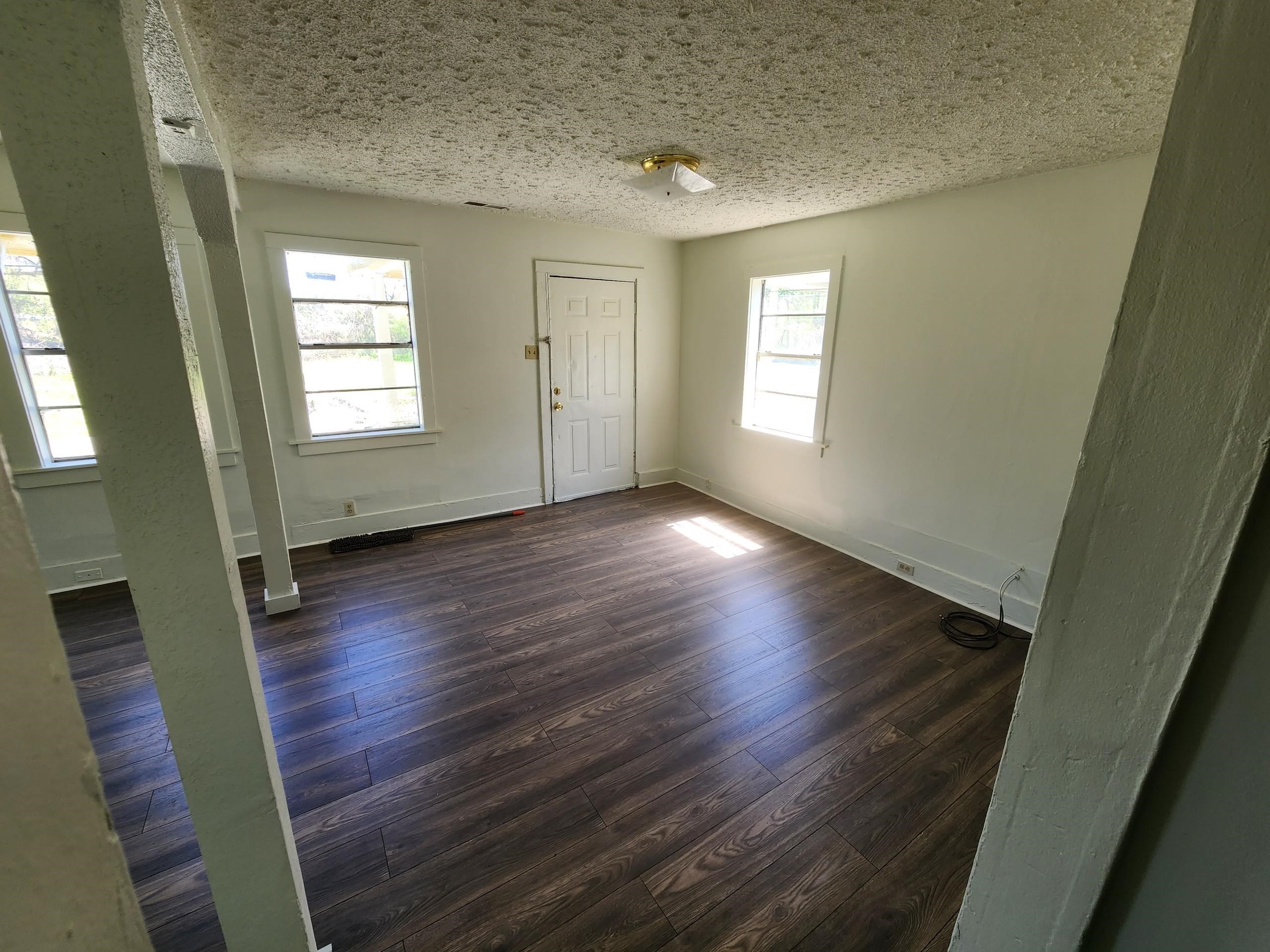 1393 Michigan Street Memphis, TN 38106 - Photo 10 of 27 a view of an empty room with wooden floor and a window