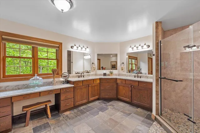 a bathroom with a granite countertop sink a mirror and a bathtub