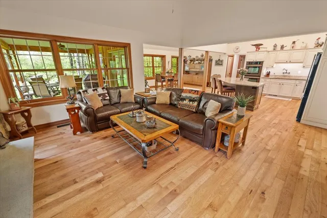 a dining hall with stainless steel appliances granite countertop a stove oven and a dining table with wooden floors