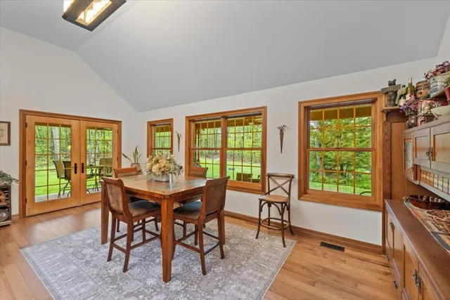 a large kitchen with kitchen island a stove a sink a dining table and chairs with wooden floor