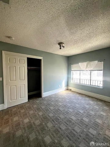 an empty room with windows and closet