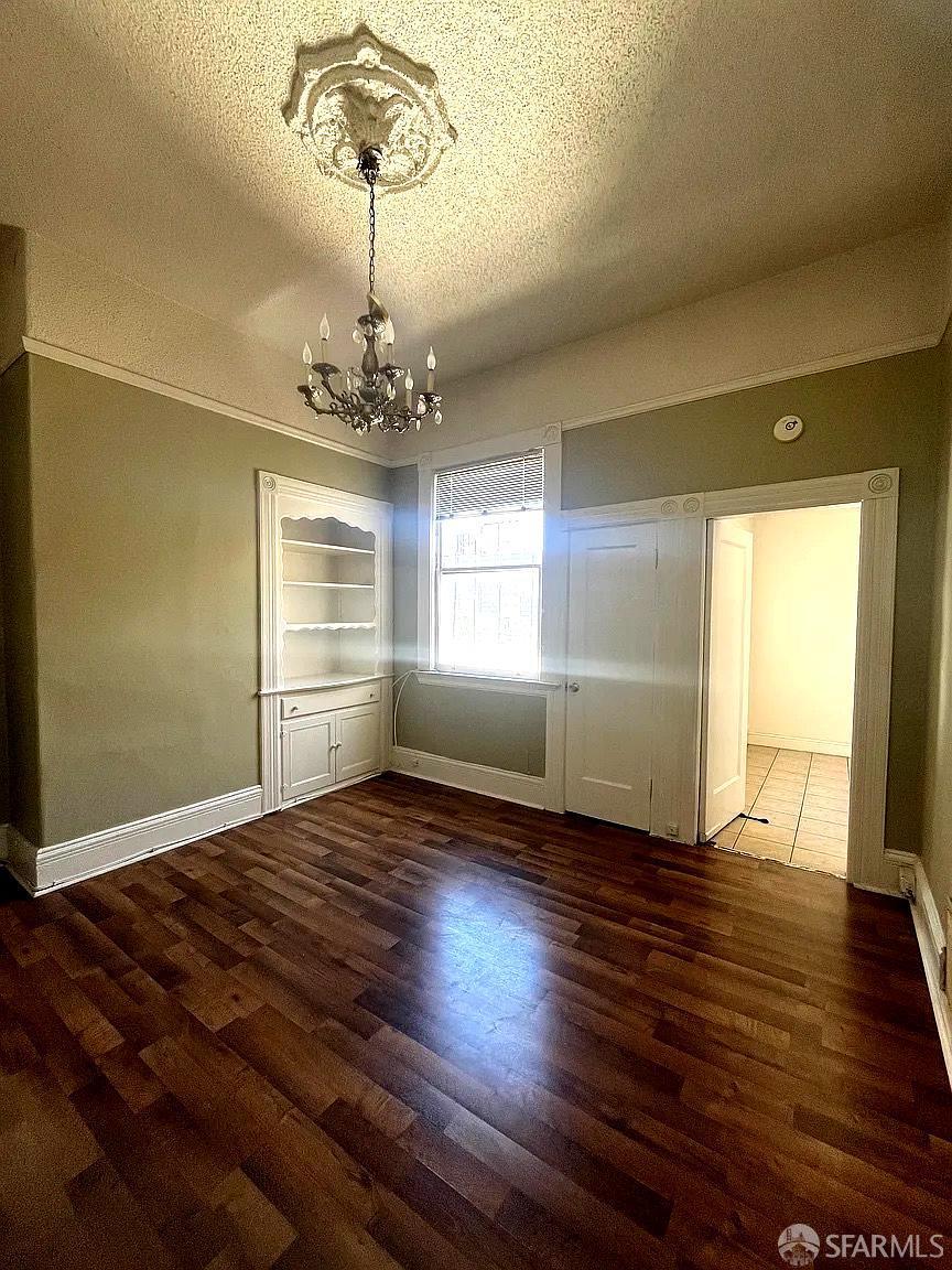 3173 21st Street San Francisco, CA 94110 - Photo 17 of 21 an empty room with wooden floor chandelier and windows