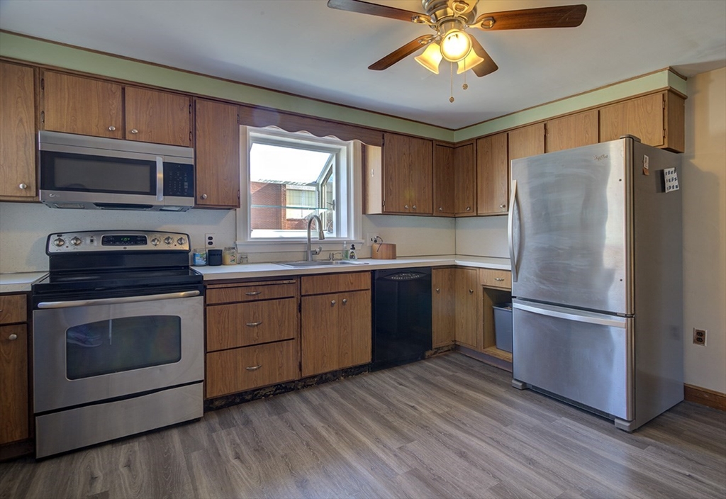 29 Perley Street Lynn, MA 01905 - Photo 7 of 27 a kitchen with a refrigerator sink and wooden cabinets