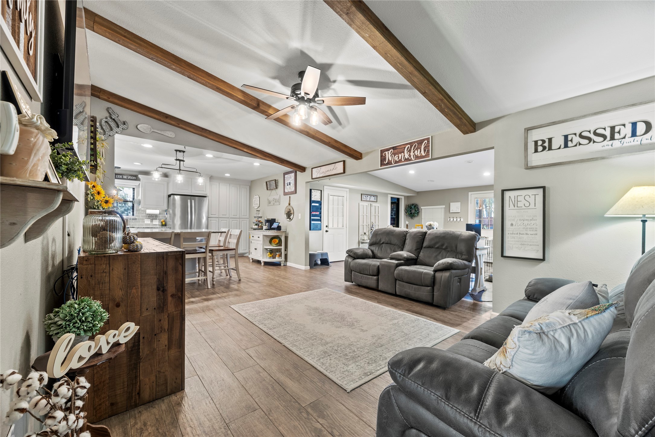 1203 Lemm Road 2 Spring, TX 77373 - Photo 5 of 21 The spacious living area features exposed wood ceiling beams and a rustic entertainment center with an integrated electric fireplace, creating a cozy atmosphere for relaxing.