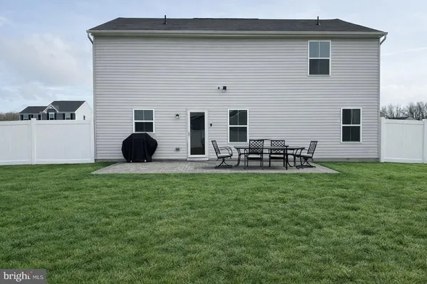 a backyard of a house with table and chairs