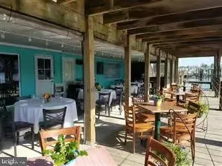 a view of a patio with dining table and chairs and potted plants