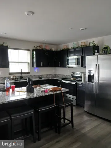 a kitchen with stainless steel appliances a stove a sink a microwave a refrigerator and cabinets