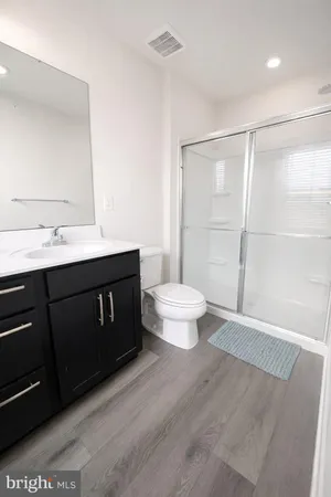 a bathroom with a sink a toilet a mirror and shower