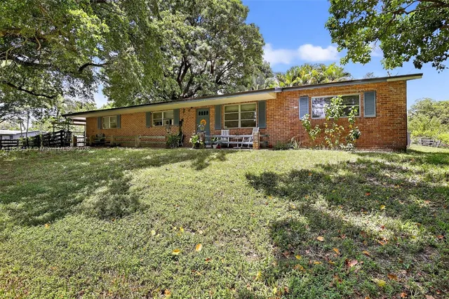 a view of a house with a yard and sitting area