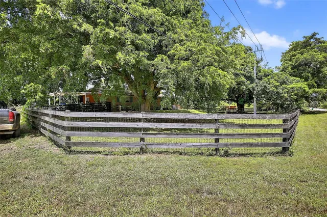 a view of backyard with wooden fence and trees