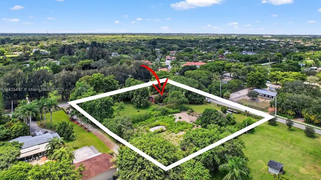 an aerial view of residential houses with outdoor space and trees