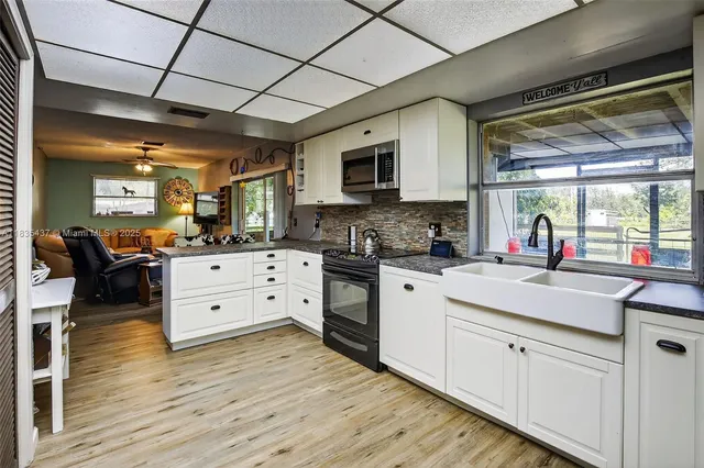 a kitchen with granite countertop a stove cabinets and wooden floor