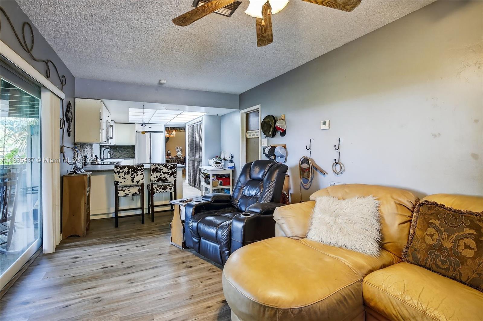 13851 Southwest 26th Street Davie, FL 33325 - Photo 6 of 48 a living room with furniture and kitchen view