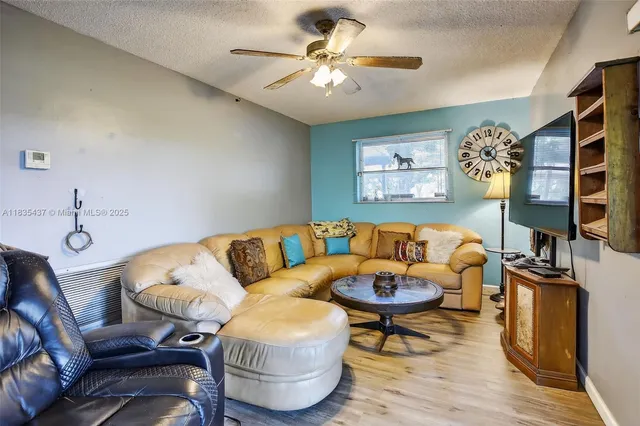 a living room with furniture a flat screen tv and a table