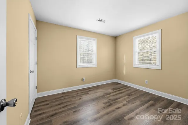 an empty room with wooden floor and closet