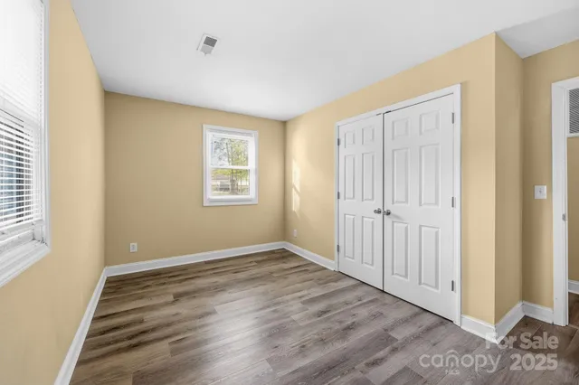a view of empty room with stairs and wooden floor