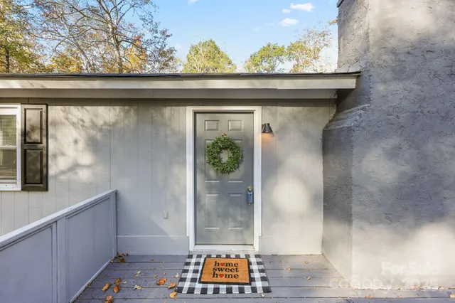 a view of backyard with small deck and wooden floor
