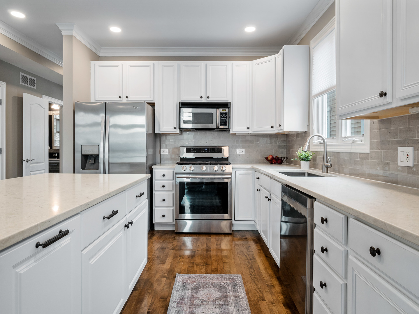 2452 West Dakin Street Chicago, IL 60618 - Photo 15 of 39 a kitchen with granite countertop a refrigerator stove and white cabinets