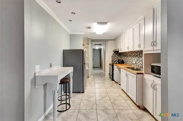 a kitchen with stainless steel appliances kitchen island granite countertop a refrigerator and a stove top oven