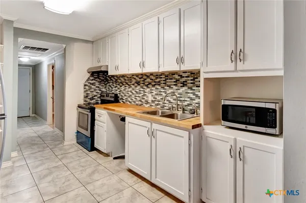 a kitchen with white cabinets and appliances