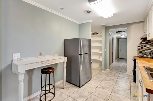 a kitchen with stainless steel appliances granite countertop a refrigerator and a stove