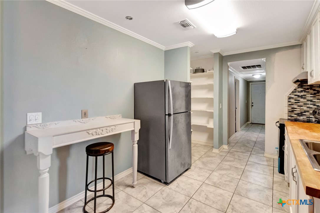 1303 East North Street Victoria, TX 77901 - Photo 14 of 36 a kitchen with stainless steel appliances granite countertop a refrigerator and a stove