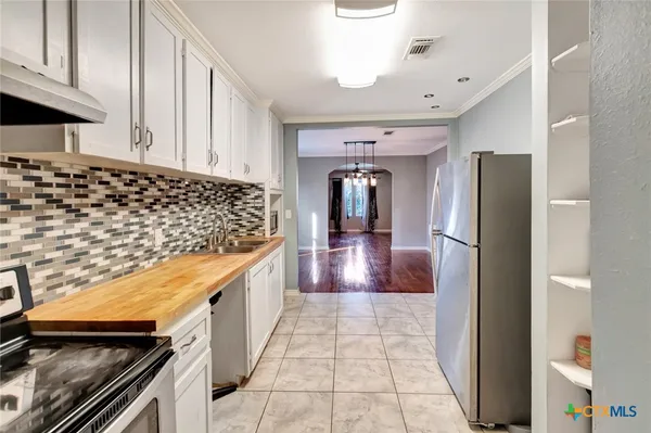 a kitchen with stainless steel appliances granite countertop a refrigerator and a stove