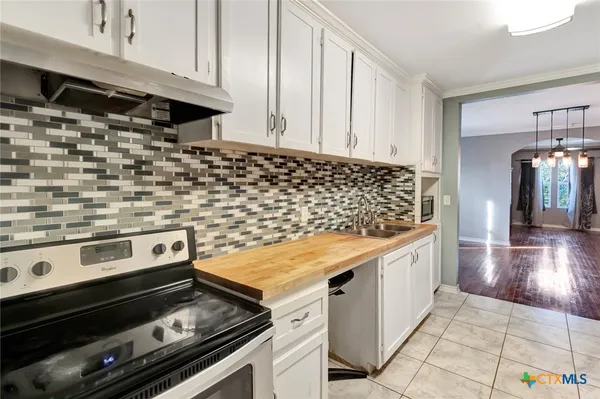 a kitchen with a stove and white cabinets