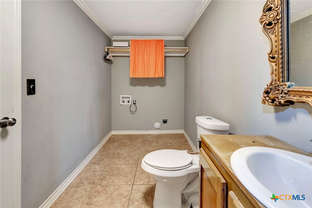 1303 East North Street Victoria, TX 77901 - Photo 19 of 36 a white toilet sitting next to a bathroom sink