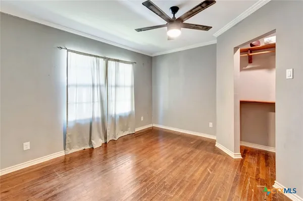 wooden floor in an empty room with a window