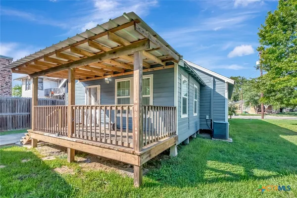 a view of a house with a small yard and wooden fence