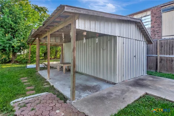 a backyard of a house with plants and tree
