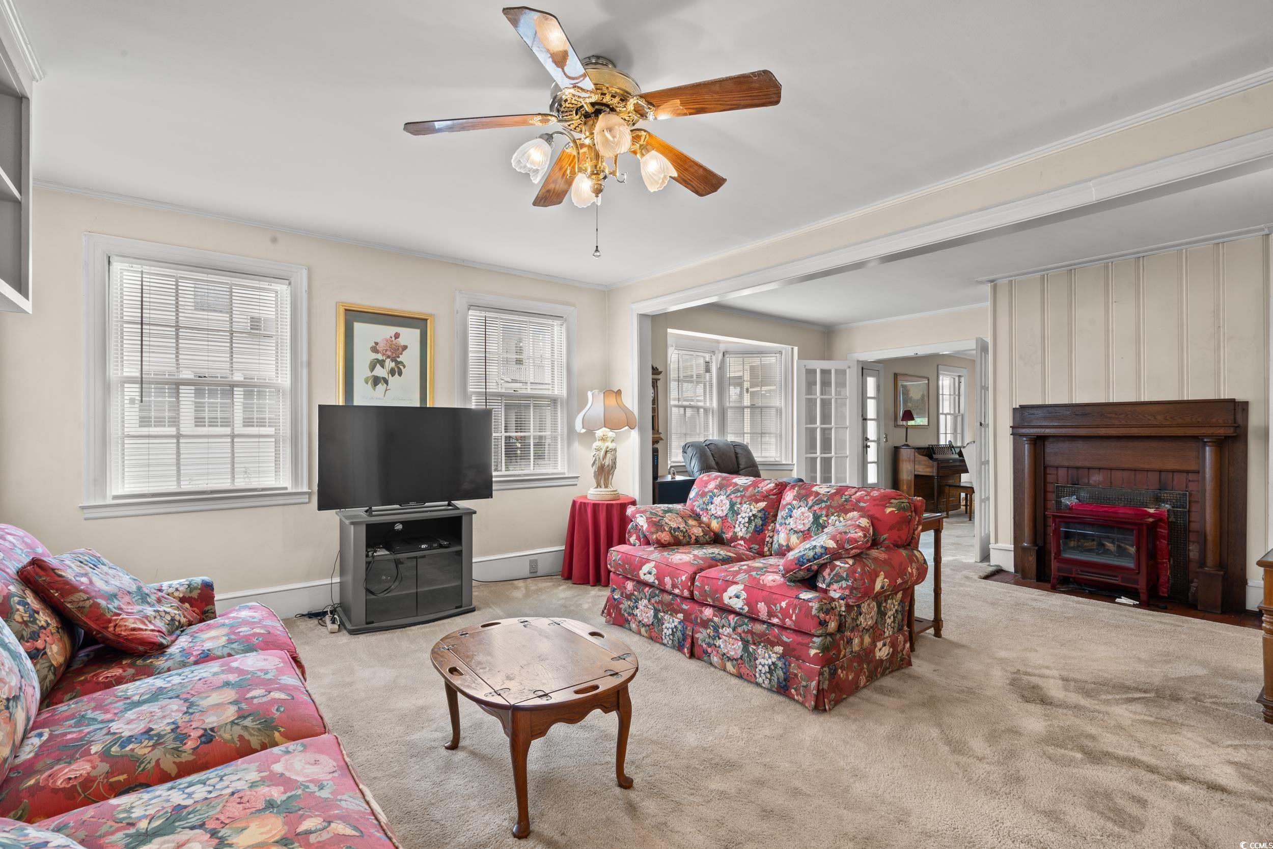310 North Main Street Mullins, SC 29574 - Photo 24 of 35 Carpeted living area featuring plenty of natural light, a ceiling fan, and a fireplace with flush hearth