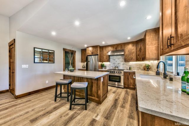 a kitchen with stainless steel appliances granite countertop wooden cabinets a stove top oven a sink and dishwasher