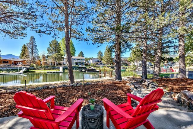 a lake view with a sitting space and trees