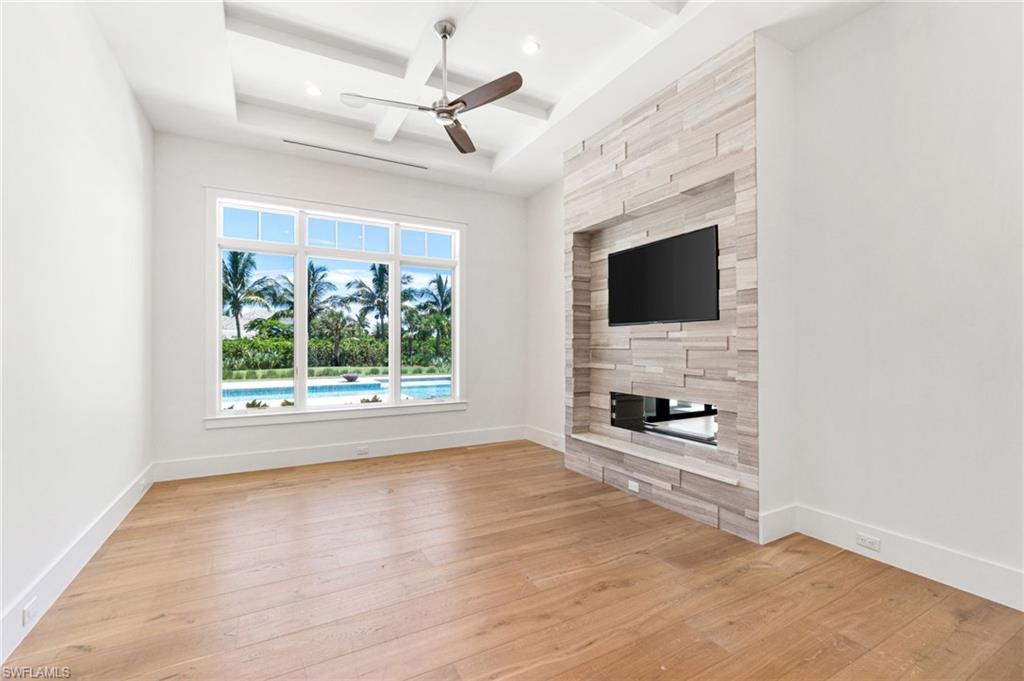 171 North Street Naples, FL 34108 - Photo 12 of 50 Unfurnished living room with light hardwood / wood-style flooring, coffered ceiling, french doors, and tile walls