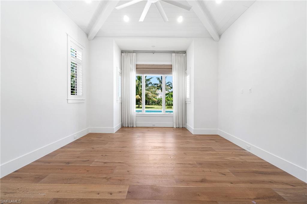 171 North Street Naples, FL 34108 - Photo 13 of 50 Unfurnished living room with beam ceiling, light hardwood / wood-style floors, a notable chandelier, and coffered ceiling