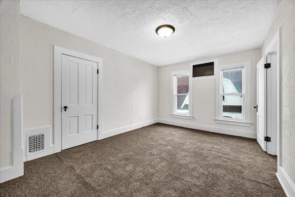 an empty room with windows and closet