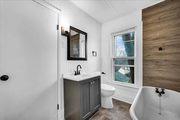 a bathroom with a toilet a sink and mirror