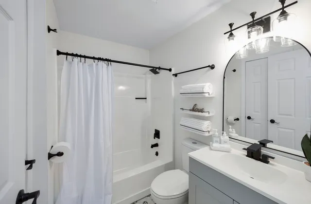 a bathroom with a sink a toilet and shower