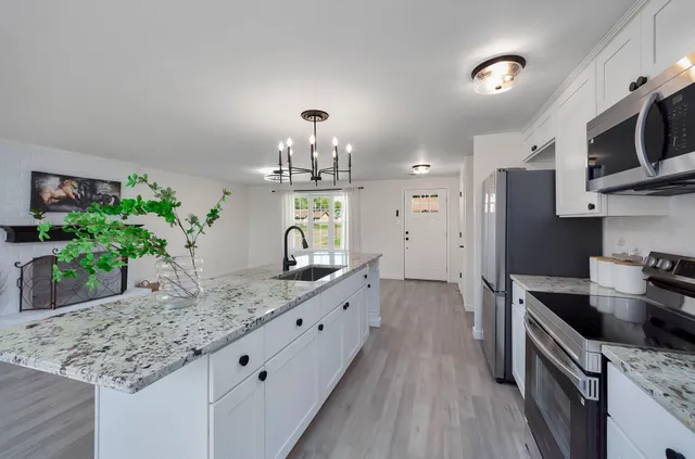 a kitchen with stainless steel appliances granite countertop a sink stove and refrigerator