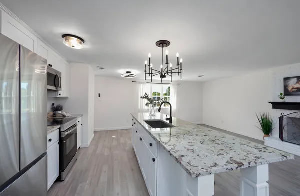 a kitchen with granite countertop a sink stove and refrigerator