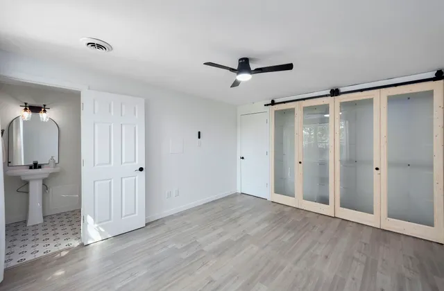a view of empty room with wooden floor and ceiling fan