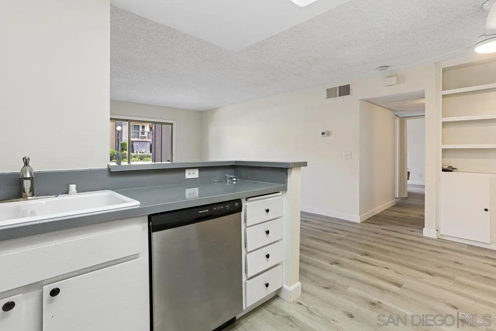 6052 Rancho Mission Road, Unit 411 San Diego, CA 92108 - Photo 3 of 21 a kitchen with granite countertop a sink and a stove