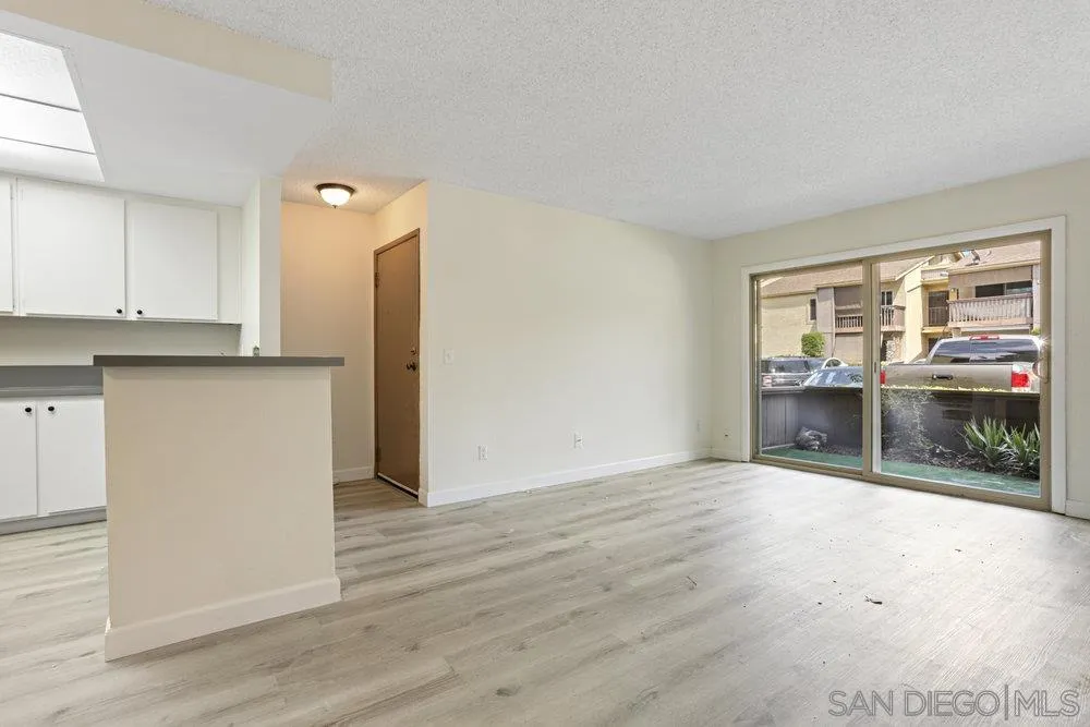6052 Rancho Mission Road, Unit 411 San Diego, CA 92108 - Photo 8 of 21 an empty room with wooden floor and windows