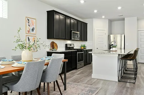 a kitchen with a table chairs sink and cabinets