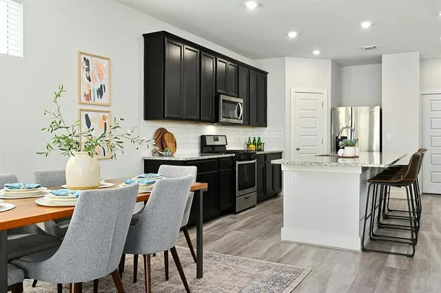 a kitchen with a table chairs sink and cabinets